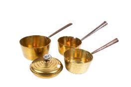 Three vintage brass saucepans and a circular hot water warmer. Max. diameter 20cm. (4).
