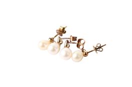 Two pairs of cultured pearl earrings on yellow metal mounts.