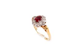 An 18ct gold, ruby and diamond dress ring. The central oval cut ruby of circa 0.