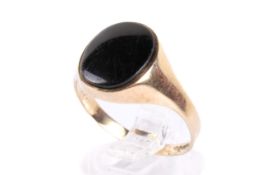 A 9ct gold and onyx ring. The oval stone of circa 1.2cm x 1cm, size R, gross weight 2.2g.