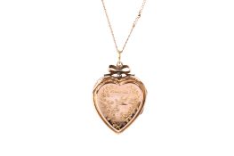 A yellow metal heart locket and chain.