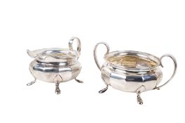 A matching silver milk jug and sugar bowl.