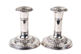 A pair of early 20th century weighted silver dressing table candlesticks.