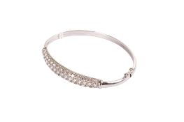 A white metal bangle set with cubic zirconia.
