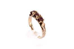 A 9ct gold (tested) three stone ruby ring. Three round faceted rubies of 0.