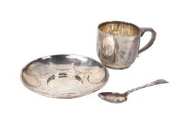 A matching silver cup and saucer together with a spoon.