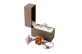 Four silver and white metal rings.