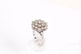 An 18ct white gold (tested) cluster ring. Set with round brilliant cut diamonds of 2.