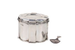 A silver tea caddy and spoon.