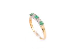An 18ct gold, emerald and diamond ring.
