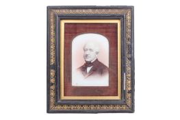 An over-painted photographic portrait of a gentleman on porcelain. Framed and glazed.