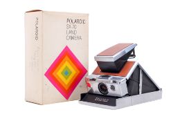 A Polaroid SX-70 Land Camera. Tan and chrome. With makers box. Untested.