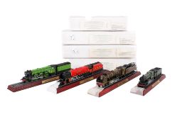 Four collectors models of locomotives mounted on track.