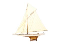A model of a gaff-rigged yacht. Constructed of wood with fabric sails, mounted on a stand.