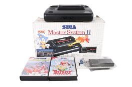A boxed SEGA, Master System II with a collection of video games and accessories.