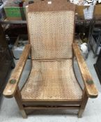 A vintage Colonial teak framed plantation chair with raffia back and seat and typical arm