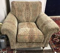A modern Parker Knoll patterned upholstered scroll arm chair on turned legs to brass castors 75cm
