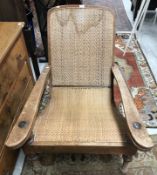 A vintage Colonial teak framed plantation chair with raffia back and seat and typical arm