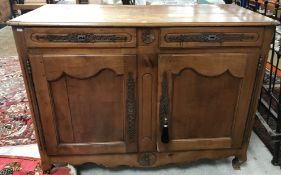 A 19th Century French walnut buffet, the plank top with cleated ends and moulded edge,