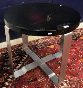 A Ralph Lauren occasional table with circular black lacquered top on polished steel supports,