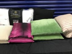 A collection of sixteen cushions in various colours and fabrics,