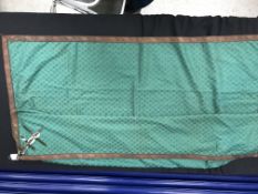 A box containing a green silk work table cover with copper wire braid and tassels,