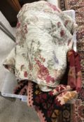 A box containing various textiles to include a modern Durham style quilt with floral pattern to one