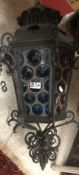A circa 1900 wrought iron and glazed hanging lantern with lime green glass panels approx.
