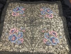 A box containing a black silk piano shawl with pink and blue floral and foliate design,