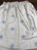 Three curtains in a caramel coloured silk type fabric with stylised flower heads in cream and brown,