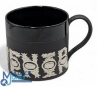 A Wedgwood Black Basalt Sporting Mug, designed by Richard Guyatt CBE, 1966, ornamented in white