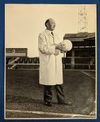 Early 1960s b&w photograph with press stamp Matt Busby on the pitch at Old Trafford and wearing