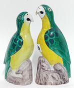 A 19th/20th century pair of Chinese ceramic parrots, green and yellow glazed, the larger 20cm