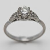 An 18ct white gold diamond solitaire ring set with further diamonds to the shoulders, size P.