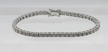 An 18ct white gold diamond line tennis bracelet, approx 5.8ct with fifty two diamonds, length approx