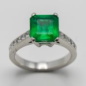 A platinum emerald and diamond set ring, central square cut emerald of good colour, set with