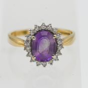 An 18ct yellow gold amethyst and diamond cluster ring, set with one oval faceted pale purple