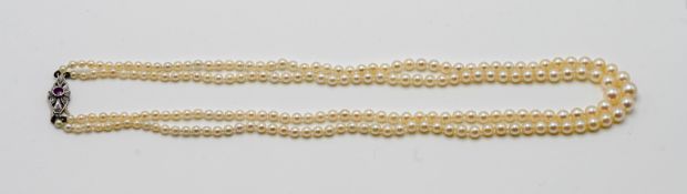 A double row pearl necklace set with ruby clasp.