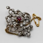 An antique diamond and ruby set brooch with safety chain, approx 35mm x 30mm
