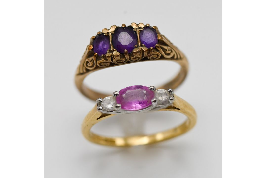 A 9ct amethyst three stone ring, approx 3.2g and an 18ct pink sapphire three stone, approx 2.9g (2)