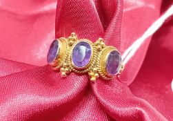 A 9ct yellow gold ring set with three amethysts, approx 3.5g, size L.