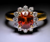 An 18ct yellow gold cluster ring set with a central oval cut orange garnet, approx. 2.50 carats,