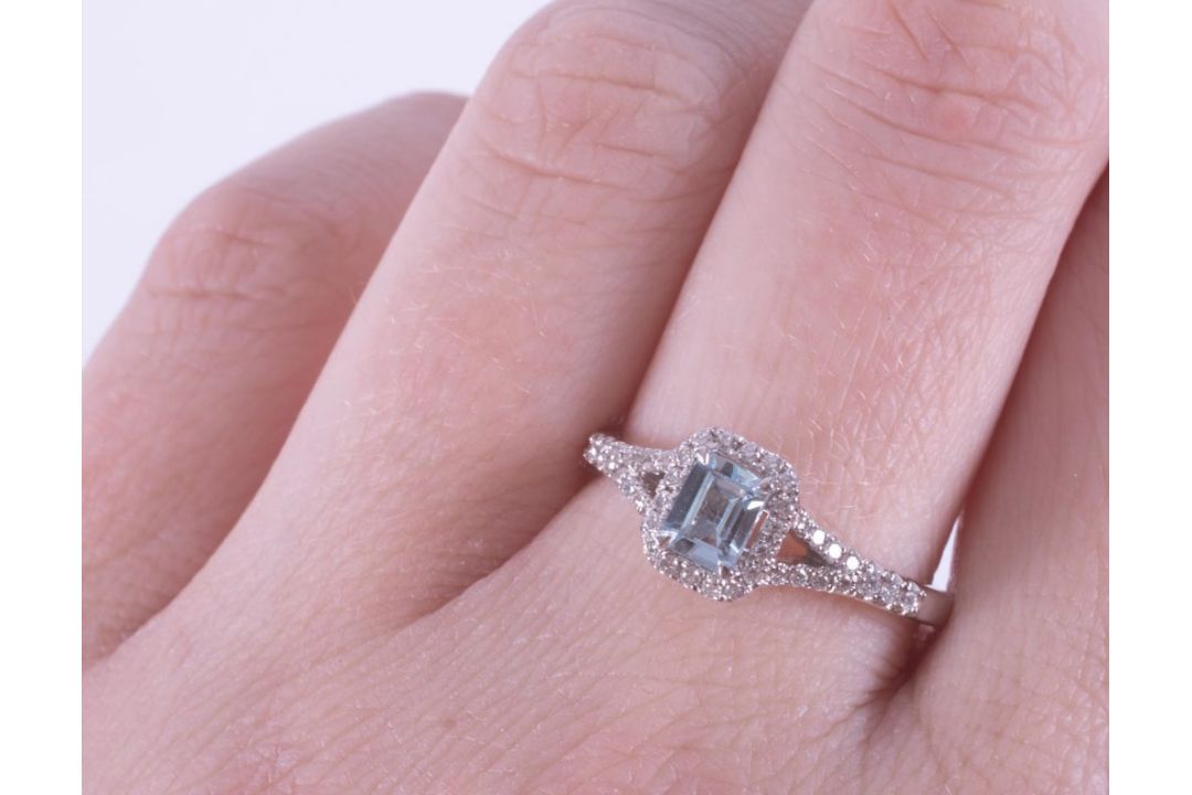 An 18ct white gold ring set with a central emerald cut aquamarine, approx. 0.50 carats, surrounded - Image 2 of 2