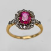 An 18ct yellow gold diamond cluster ring set with a red gem stone, band misshaped, size M.