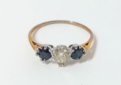 A 9ct gold three stone ring, comprising central old cut diamond with one round cut sapphire set