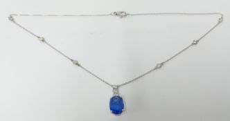 A fine oval cut tanzanite pendant set with diamonds, with14k white gold chain.