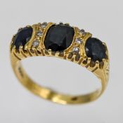 A sapphire and diamond three stone ring set in 18ct yellow gold, approx 6.6g, size T/U.