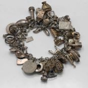 A silver charm bracelet set with various silver charms including cowboy hat, passport, pig, bird
