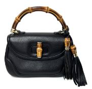 Gucci, a vintage bamboo handle tassel black leather bag with a front flap opening, curved bamboo