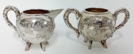 A Chinese silver cream Jug and Sugar Basin of globular form with ‘root’ handles and prunus in relief